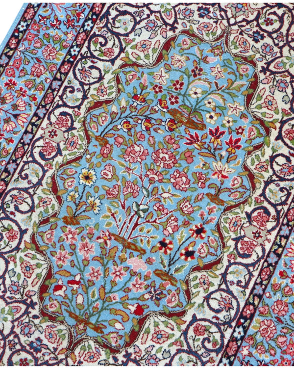 Tappeto Kerman persiano 147x100 cm annodato a mano, fondo azzurro con medaglione centrale e motivi floreali dettagliati in tonalità avorio e rosa