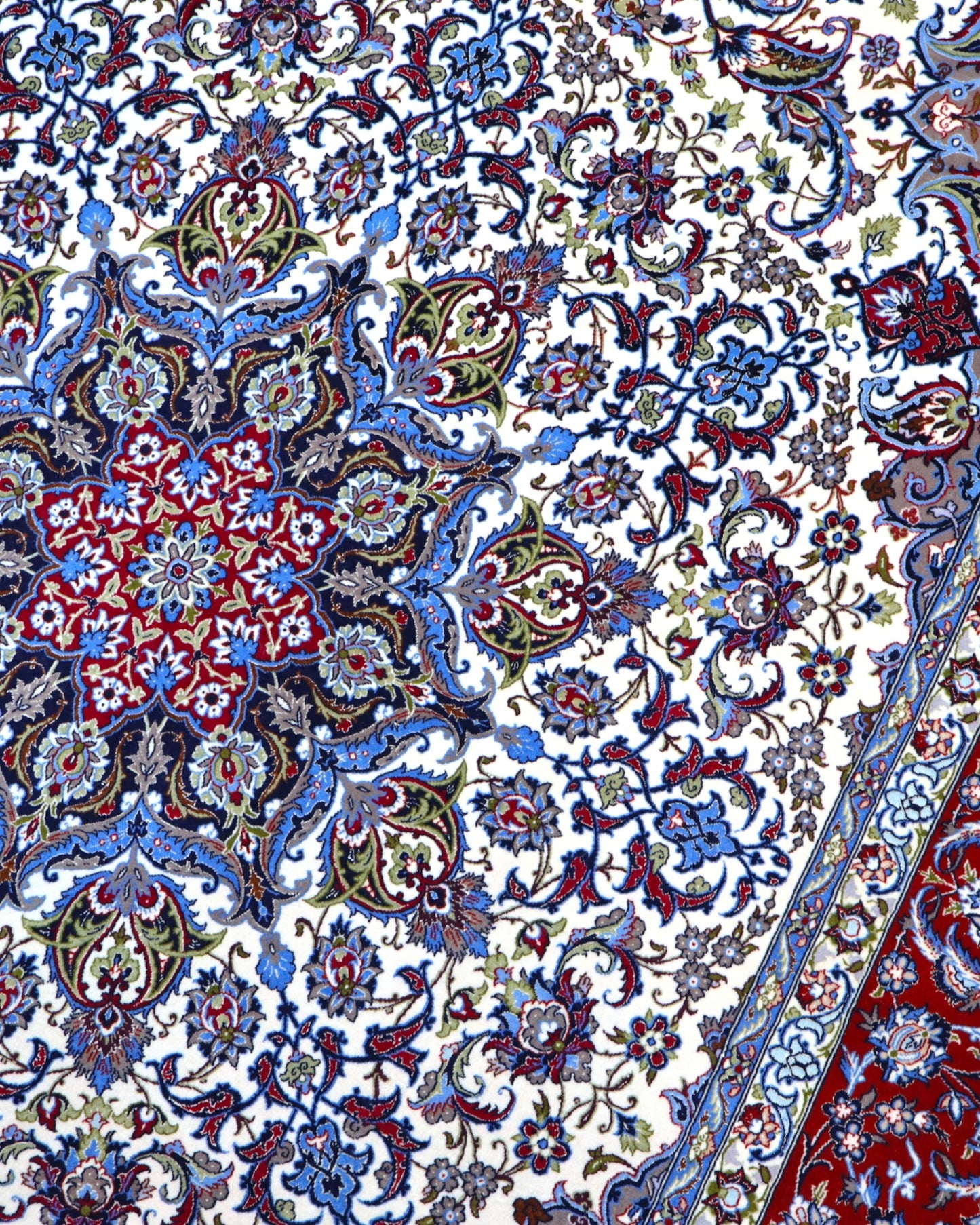 "Tappeto Esfahan annodato a mano con motivi floreali in blu, rosso, oro e marrone su fondo avorio, 306x203 cm."