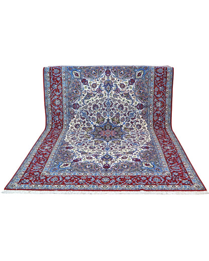 "Tappeto Esfahan annodato a mano con motivi floreali in blu, rosso, oro e marrone su fondo avorio, 306x203 cm."