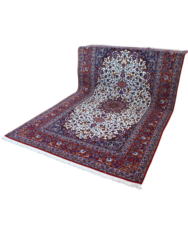 "Tappeto Esfahan annodato a mano con motivi floreali nei toni del blu, rosso, oro e marrone su fondo avorio, 340x208 cm."