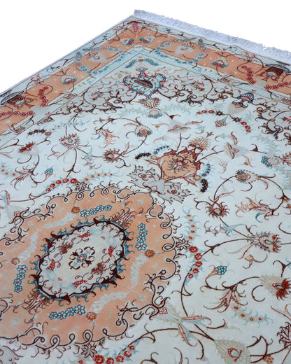 "Tappeto Tabriz annodato a mano, con motivi floreali in blu, rosso e oro su fondo chiaro, 208x200 cm."