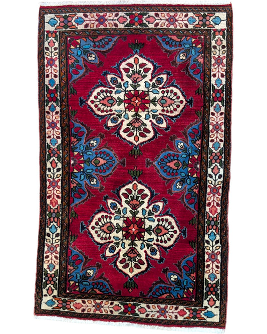 Tappeto Hamedan persiano 167x100 cm annodato a mano, fondo rosso con motivi floreali avorio e dettagli blu, design tradizionale con medaglioni simmetrici
