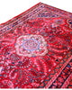Tappeto Lilian persiano 149x112 cm annodato a mano, fondo rosso con medaglione floreale centrale e motivi decorativi in rosa e blu