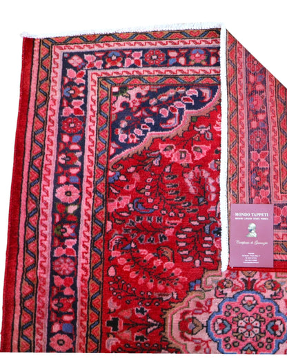 Tappeto Lilian persiano 149x112 cm annodato a mano, fondo rosso con medaglione floreale centrale e motivi decorativi in rosa e blu