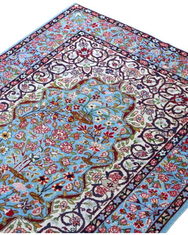 Tappeto Kerman persiano 147x100 cm annodato a mano, fondo azzurro con medaglione centrale e motivi floreali dettagliati in tonalità avorio e rosa