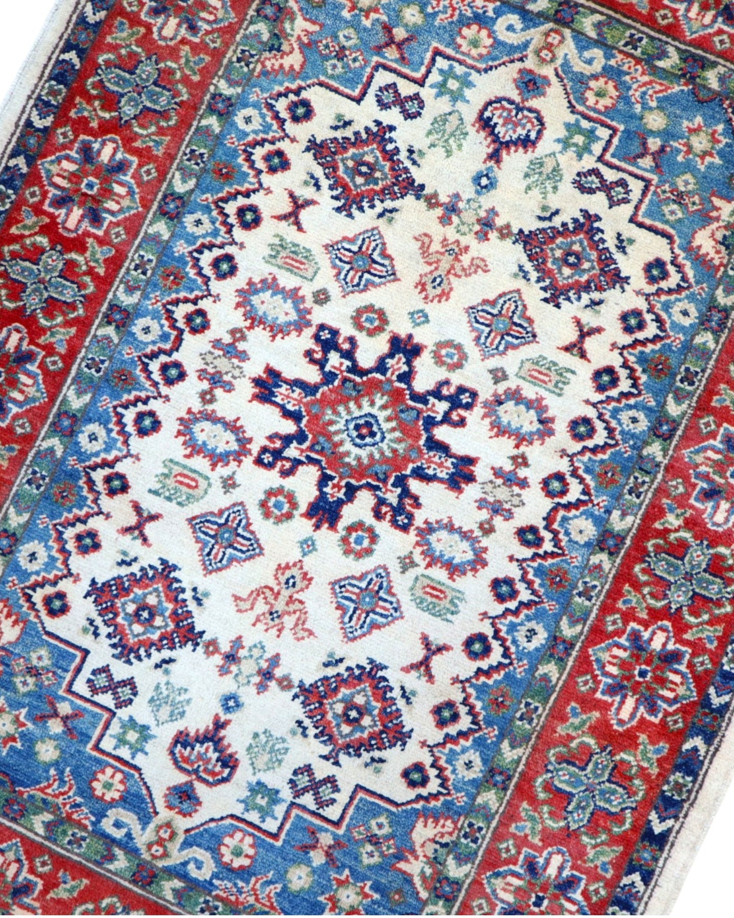 Tappeto Kazak 144x102 cm con dettagli geometrici e fiori, perfetto per camera da letto.